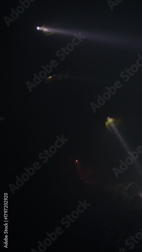 Rescue forces search for survivors inside a dark tunnel using flashlights