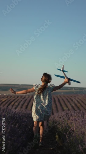 Girl running airplane lavender field dreaming of flying freedom and joy at sunset Vertical video