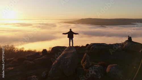 A man demonstrating scenic Cloud Inversion at the Peak District.  Cinematic Drone Landscape Exploration around Froggatt Edge, Curbar Edge and Baslow Edge, which are the most popular hiking trails.