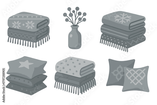Cozy home textiles and decor set including stacked blankets, pillows, and decorative vase