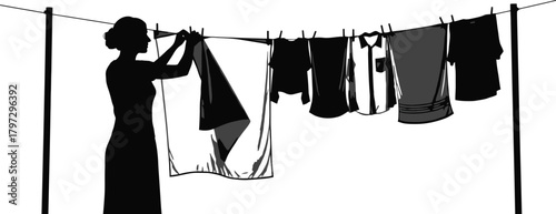 Silhouette of a woman hanging laundry on a line