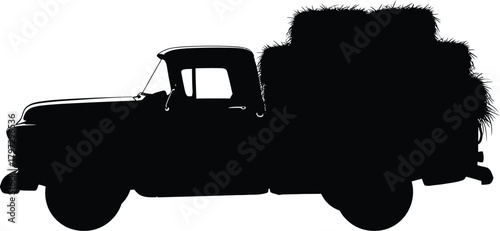 Silhouette of a vintage truck carrying hay bales