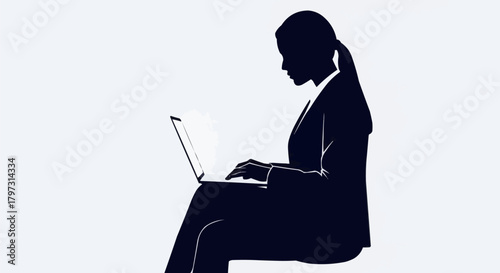 Silhouette of a woman working on a laptop computer, focused and concentrated.