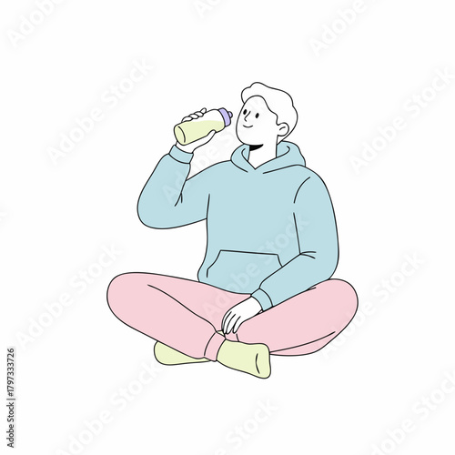 A person sitting cross-legged and drinking from a water bottle, wearing a hoodie and sweatpants.