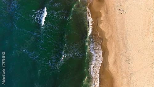 Fototapeta Naklejka Na Ścianę i Meble -  Sunlit Baltic Sea view showing calm waves and clean sandy shoreline.