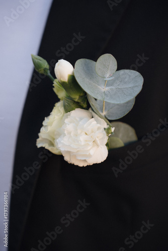 Принти на полотні Romantic white flower corsage with greenery on elegant black suit at a wedding c