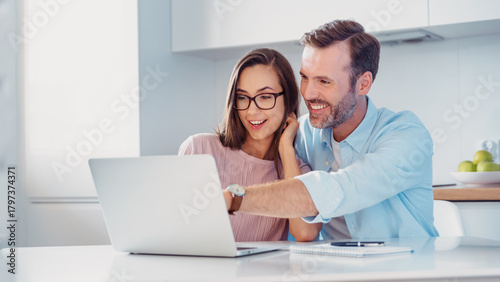 Smiling couple sitting at the computer