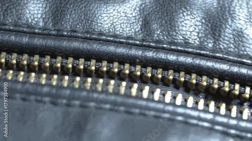 Close-up view of a shiny zipper on a leather bag