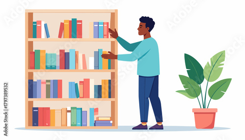 Man arranging colorful books on a wooden bookshelf with multiple shelves.