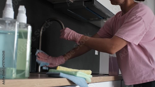 A young woman cleaning the kitchen