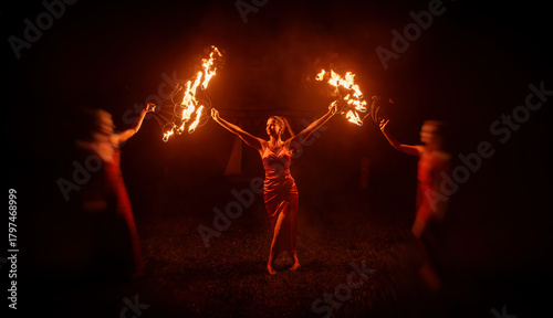 An enchanting fire dancer beautifully showcases her talent with mesmerizing flames during a performance.