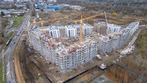 Aerial view of urban residential building construction, showing cranes and progress being made.