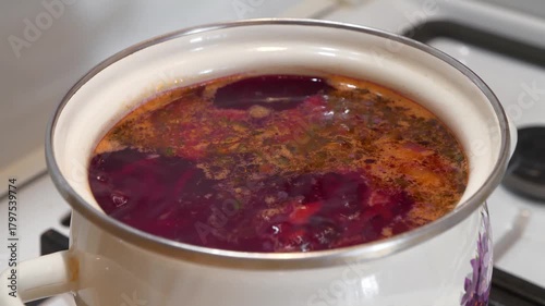 Red Ukrainian borscht is boiling in saucepan. National dish of Ukraine. Main first course of Ukrainian cuisine. Ukrainian borscht is cooked on gas stove. Cooking first courses