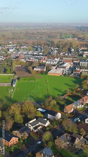 reveals village puurs belgium local town city under sunny morning skies picturesque countryside accentuated by bright sunlight aerial drone panning shot visual delight experience 