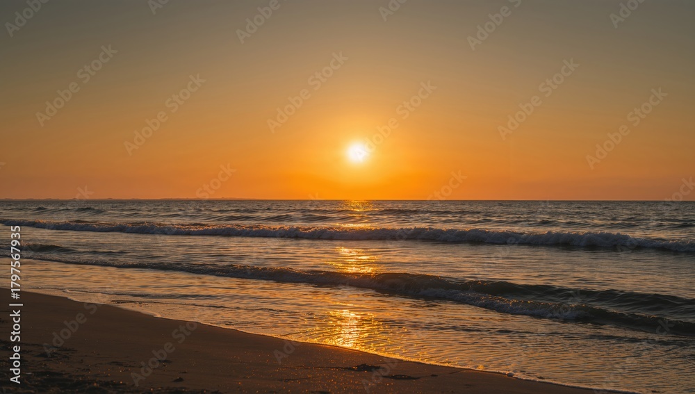 Obraz premium Sea and beach during sunrise with waves lapping at the shore, emphasizing seasonal change