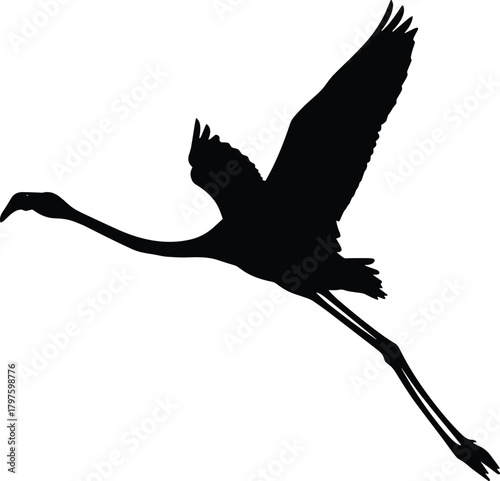 Black silhouette of a flamingo bird in flight with wings spread wide flying