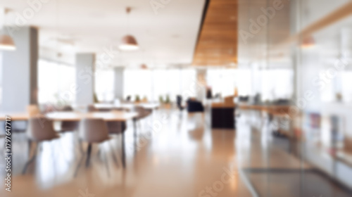 Wallpaper Mural Modern office interior with blurred focus showing tables and chairs in bright, spacious workspace filled with natural light and warm tones Torontodigital.ca