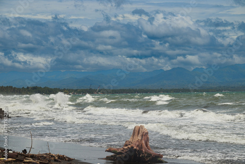 Crashing waves against the coast under a dramatic cloudy sky during the stormy monsoon season. Dipolog, Philippines