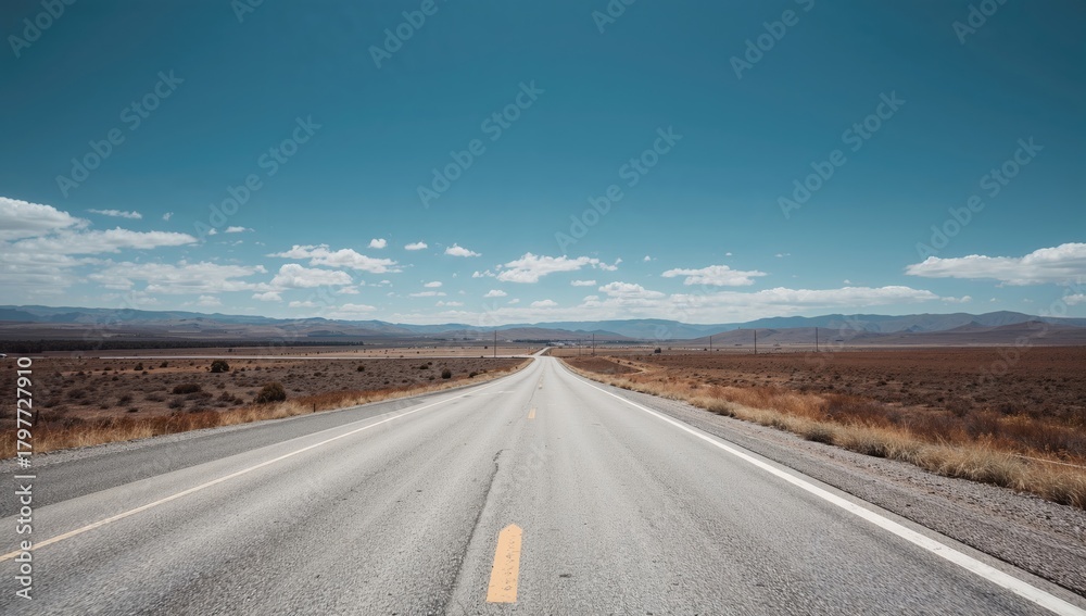 Fototapeta premium Long stretch of white asphalt against a blue landscape, potential for summer road trips