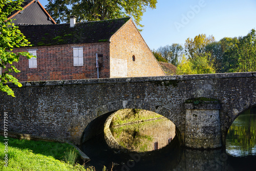 Photos Scenic Loir River landscape with old mill and stone bridge, in Illiers-Combray, a small French town known for its lovely rural setting and historic connection to famous writer Marcel Proust