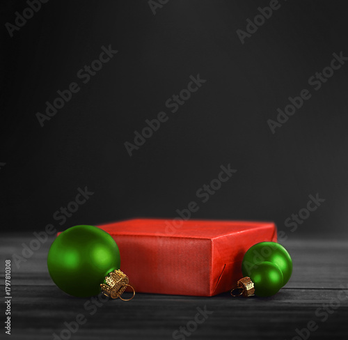 Red pedestal with green Christmas balls on a black background