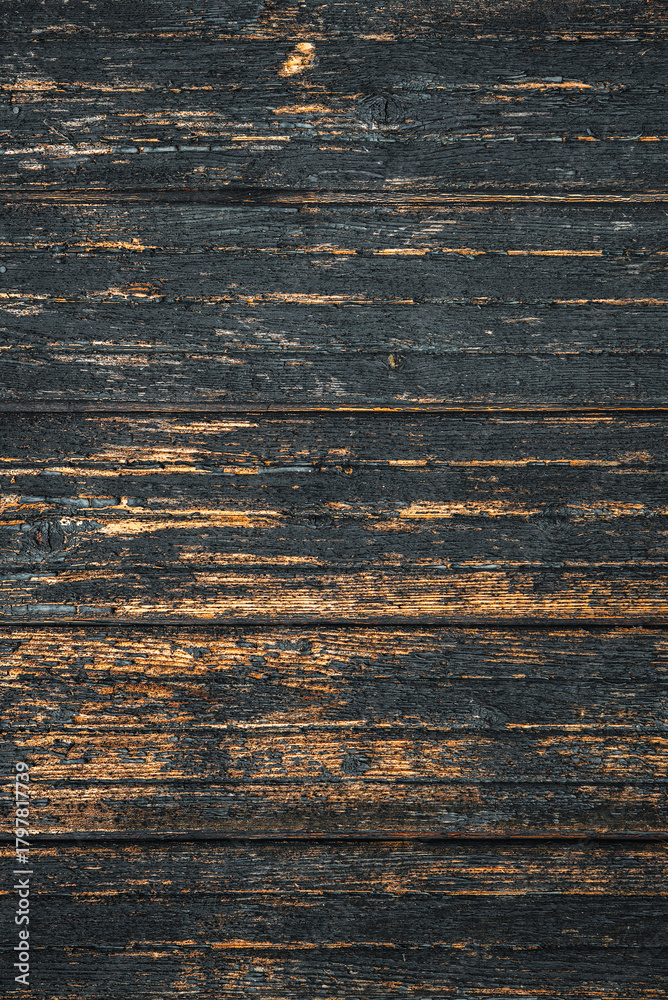 Naklejka premium Dark weathered wooden planks with rich grain patterns and subtle orange streaks, showcasing rustic texture. Concept of aged wood aesthetic