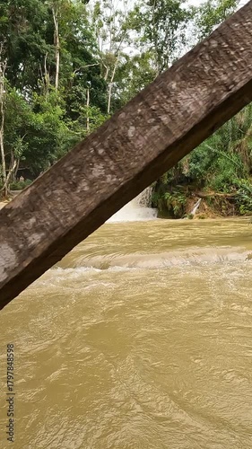 Powerful water flow at the large waterfalls near Luang Prabang -  Laos, filmed on a cloudy, wintery day, capturing the dramatic natural beauty of the scene.