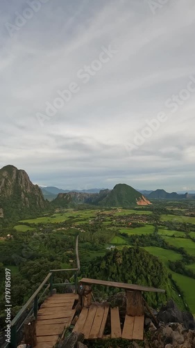 A beautiful aerial view of the lush nature surrounding Vang Vieng, Laos, showcasing mountains, rivers, and green natural landscapes from above.