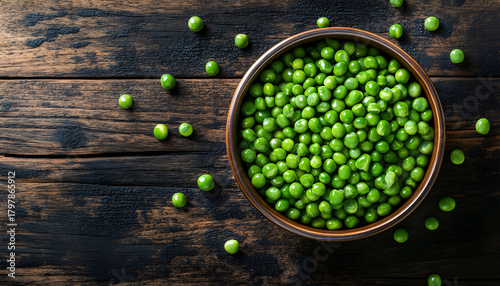 Green peas in a ceramic bowl on old wooden background