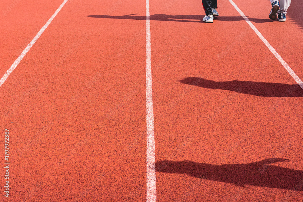 Fototapeta premium Red synthetic rubber running track for sports outdoors. Close Up of an athlete on a track or jogging track in Surabaya Stadium, Indonesia. Running track red texture background. Top View.