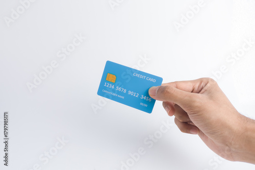 Hand holding a blue credit card with a visible microchip on a white background, symbolizing secure digital payment, contactless transaction, quick commerce, or banking service.
