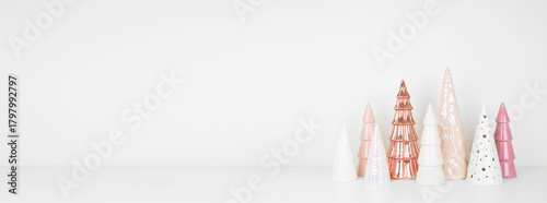 Pink and white Christmas tree decor on a white shelf against a white wall banner background with copy space