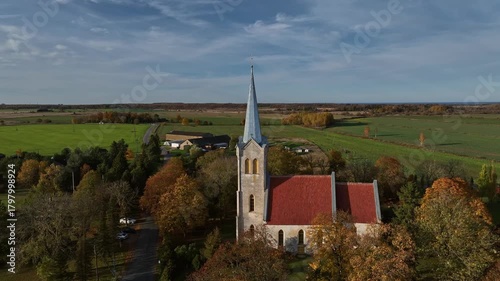 Aerial footage of one of the oldest churches in Estonia - Church of the Blessed Virgin Mary in Joelahtme (Estonian - Püha Neitsi Maarja kirik, Jõelähtme) on a sunny autumn day. 