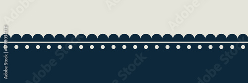 A simple decorative border with scalloped edges and polka dots separating a beige and dark blue background