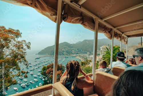 Girl with binoculars looking out of tour bus to tropical view