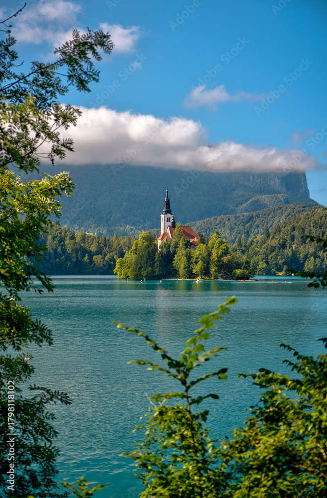 Naklejka premium Lake Bled, Slovenia – July 22, 2025: Scenic views of Bled Island and its iconic Church of the Assumption surrounded by the Julian Alps and crystal waters.
