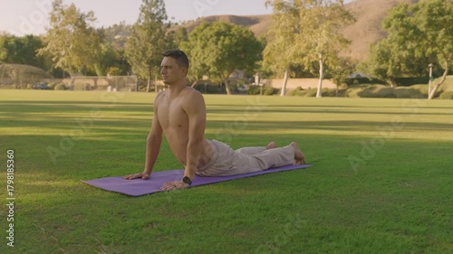 Young Fit Man Doing Outdoor Yoga and Core Workout on a Mat in the Park