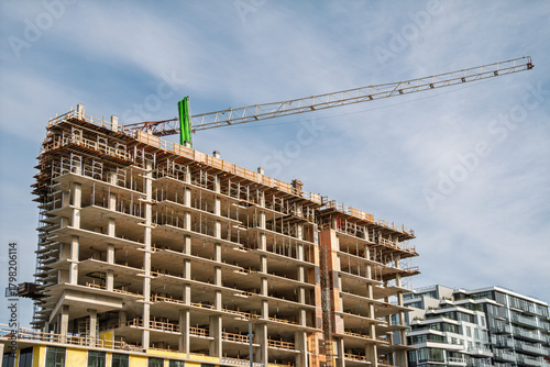 Crane and building construction site against blue sky