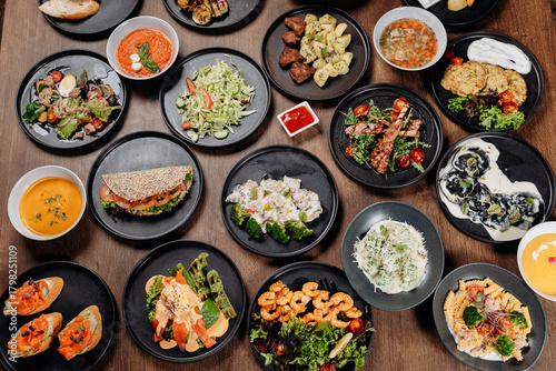 Assorted restaurant dishes on a wooden table, overhead flat lay of a catering menu