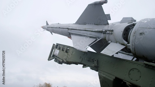 closeup of missile attached to wing pylon, aircraft missile with support structure under cloudy sky