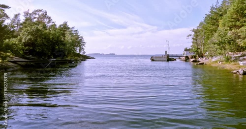 Landscape view of Nokasundet strait from moving passenger ferry in summer weather with clouds in the sky, Pirttisaari, Porvoo, Finland. 