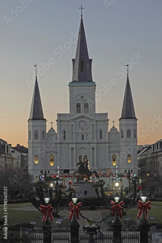 In New Orleans, Louisiana, historic Jackson Square and St. Louis Cathedral are shown decorated during the Christmas holiday season, shown in a vertical view during the evening.