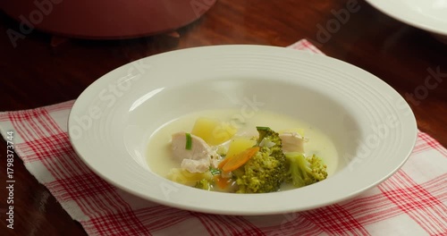 Broccoli soup. Broccoli soup blended, vegetarian soup. Pouring vegetable soup with broccoli into a plate, top view.
