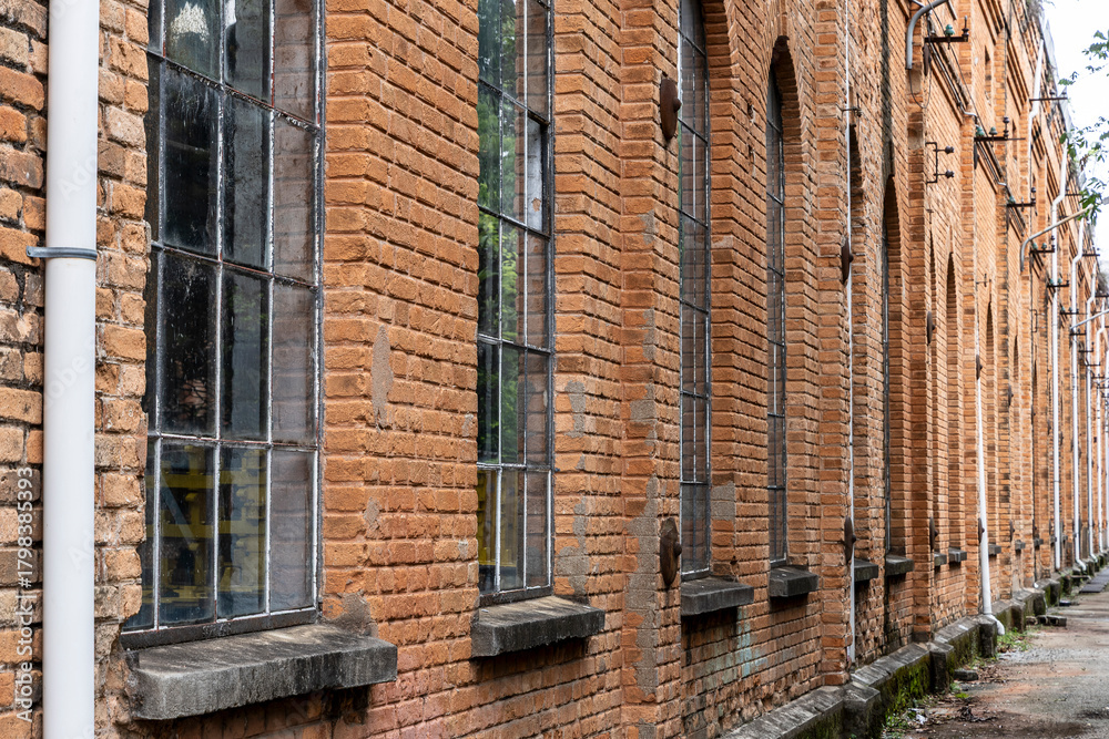 Fototapeta premium The arched windows of an old factory hall built of beautifully red bricks