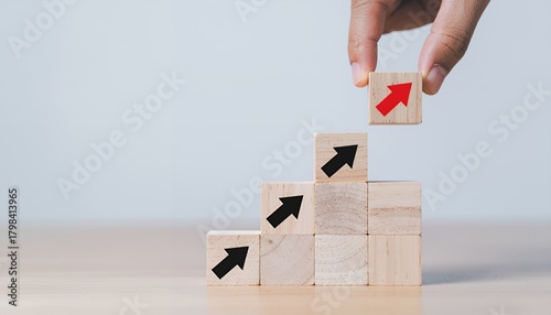Wallpaper Mural Hand placing a wooden block with an arrow, symbolizing growth and success in business. Torontodigital.ca