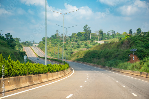 Highway linking Yaounde to Nsimalen International Airport, Cameroon. A modern and smooth road winding between green hills.
