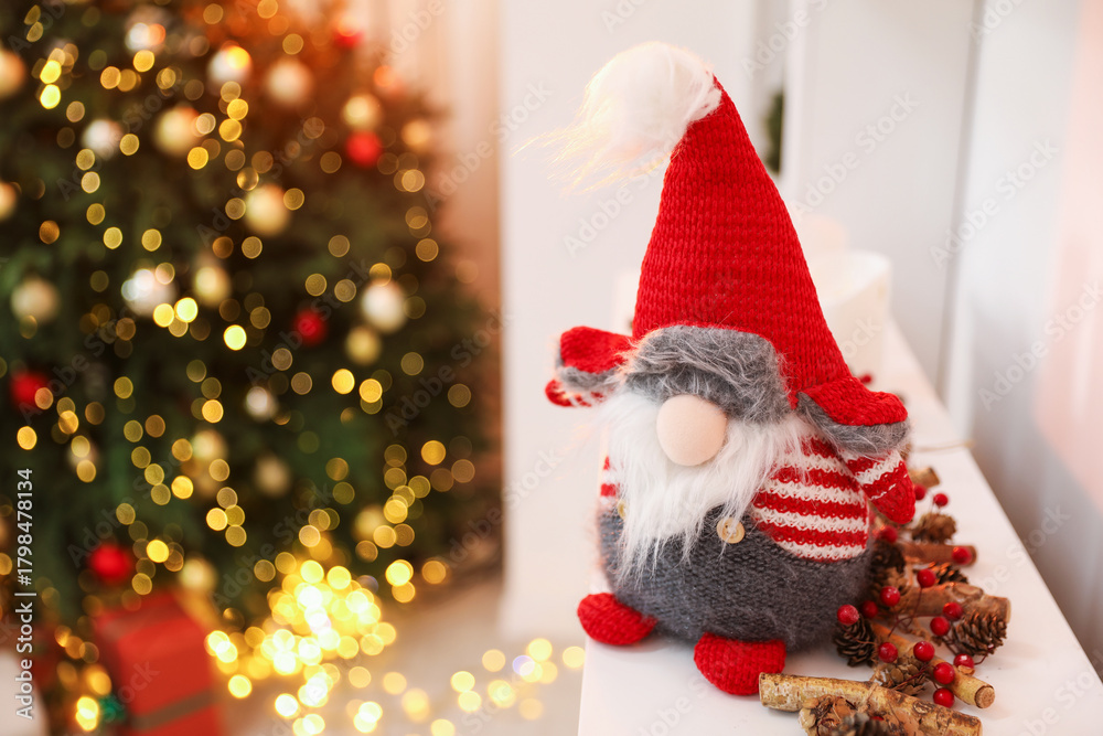Fototapeta premium Funny Christmas gnome on dresser in decorated room, closeup
