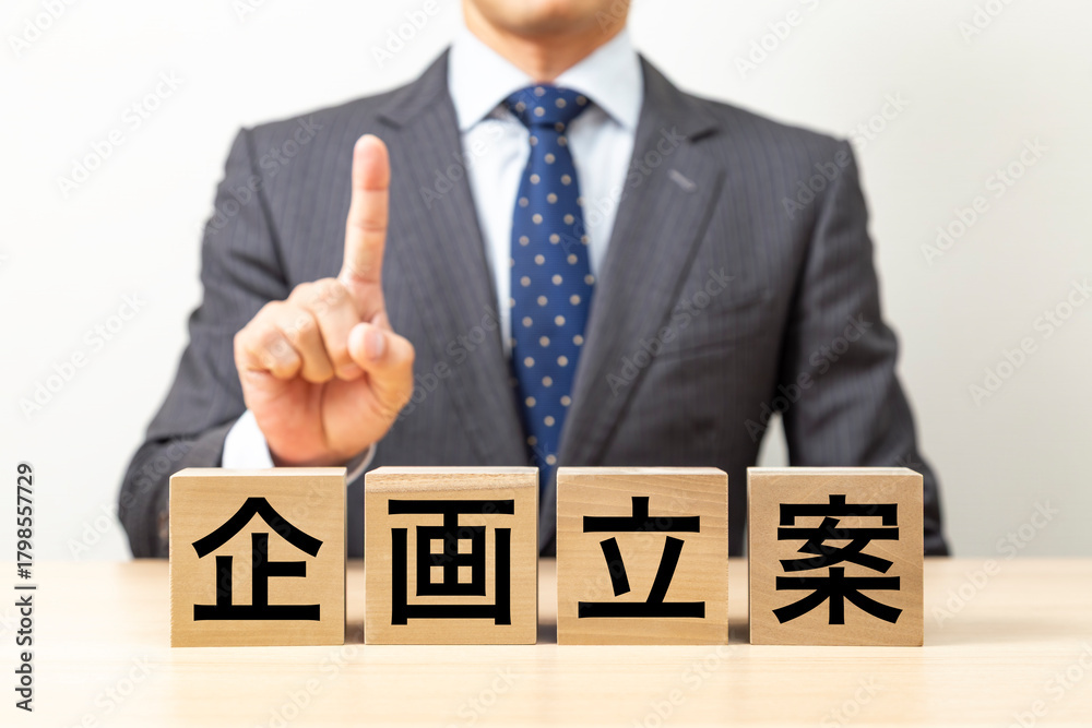 Obraz premium 「企画立案」と書かれたブロックとビジネスマン