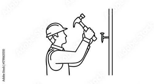 A construction worker in a hard hat uses a hammer to drive a nail into a wall, showcasing manual labor and building.
