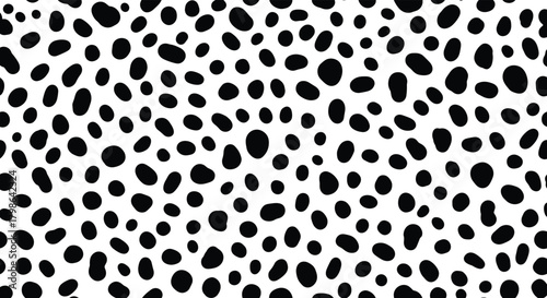 An abstract pattern of numerous black irregular dots on a white background.